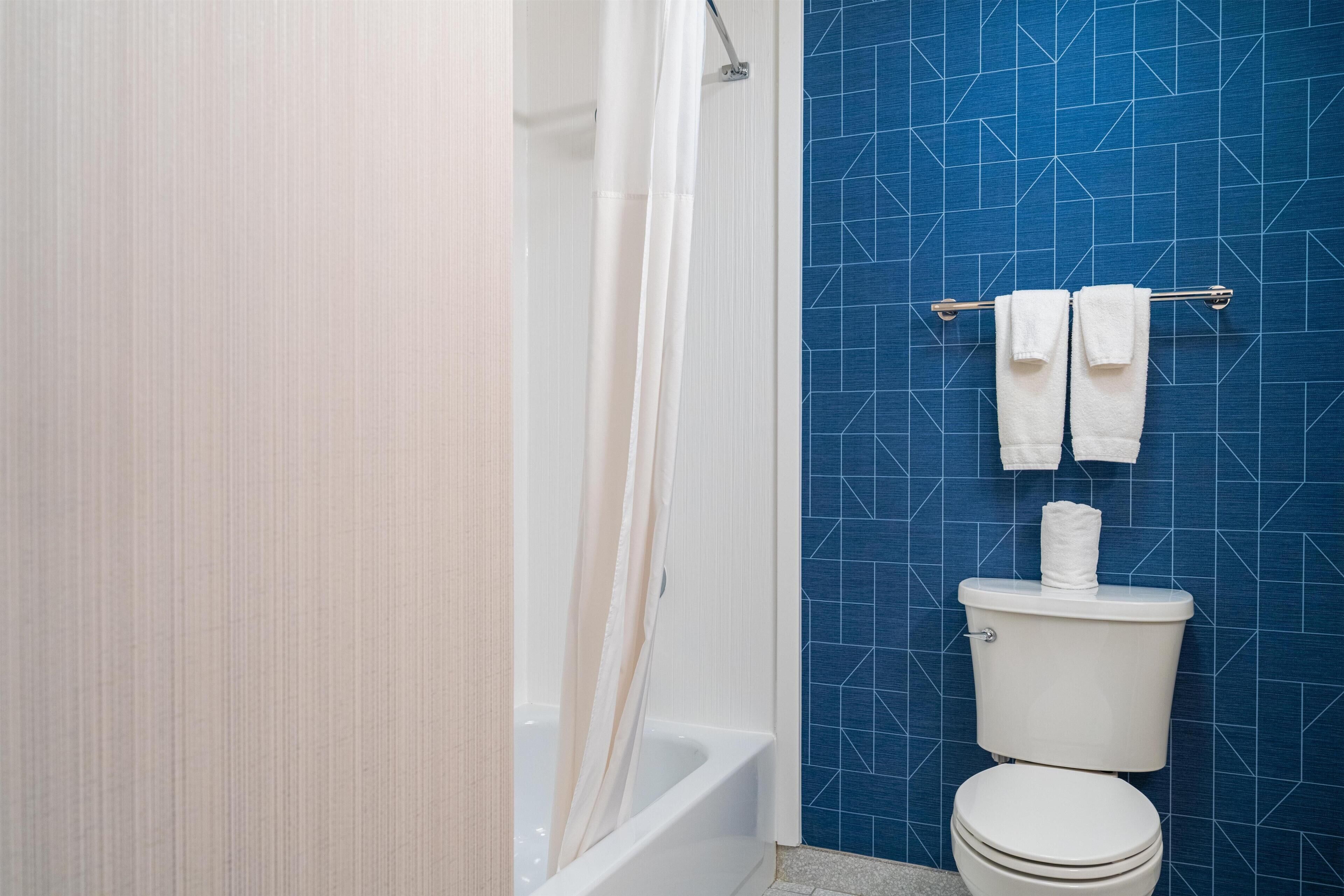 Ein Badezimmer mit Badewanne, Toilette und Handtuchhalter.