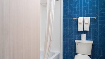 Ein Badezimmer mit Badewanne, Toilette und Handtuchhalter.