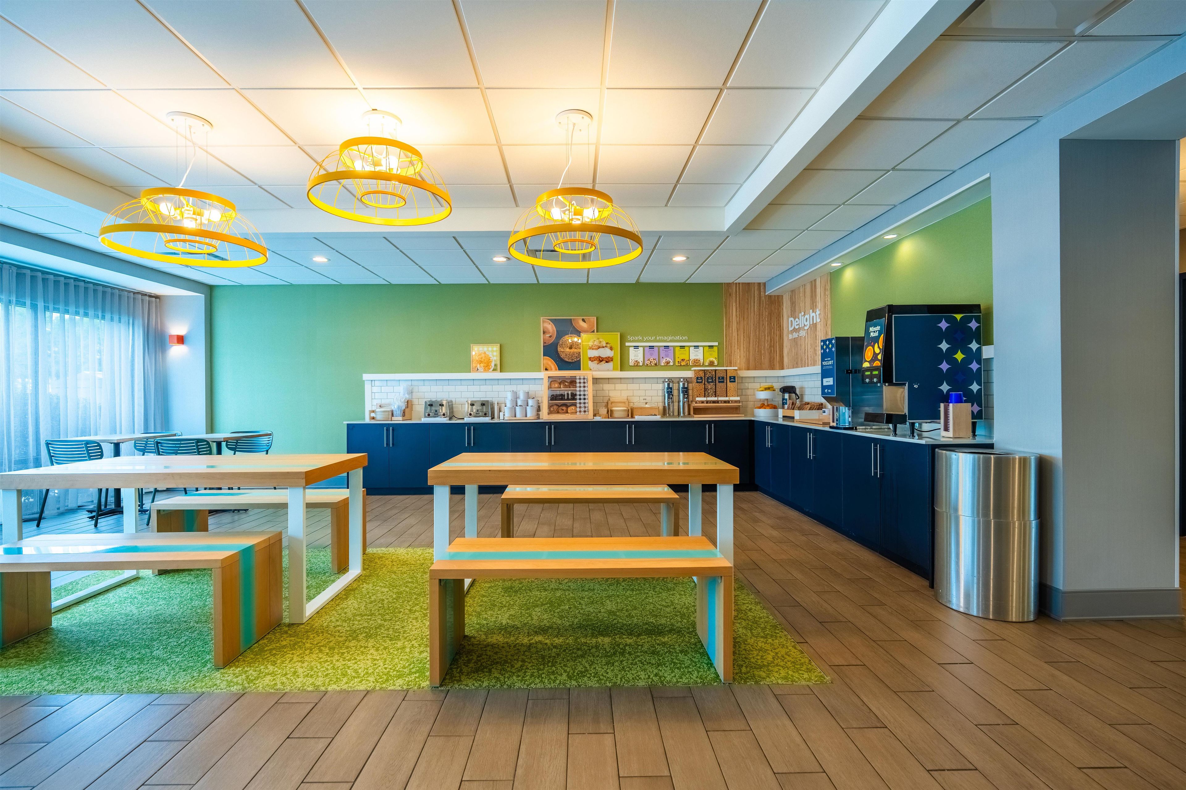 Ein moderner Küchenbereich mit Arbeitsfläche, Sitzgelegenheiten und Deckenleuchten.