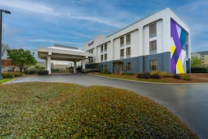 A modern hotel with a covered entrance, a parking lot, and landscaped areas. - Spark by Hilton Atlanta Kennesaw Town Center (Kennesaw)