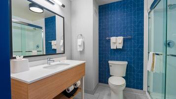 Un baño moderno con tocador de doble lavabo, inodoro y cabina de ducha de vidrio.