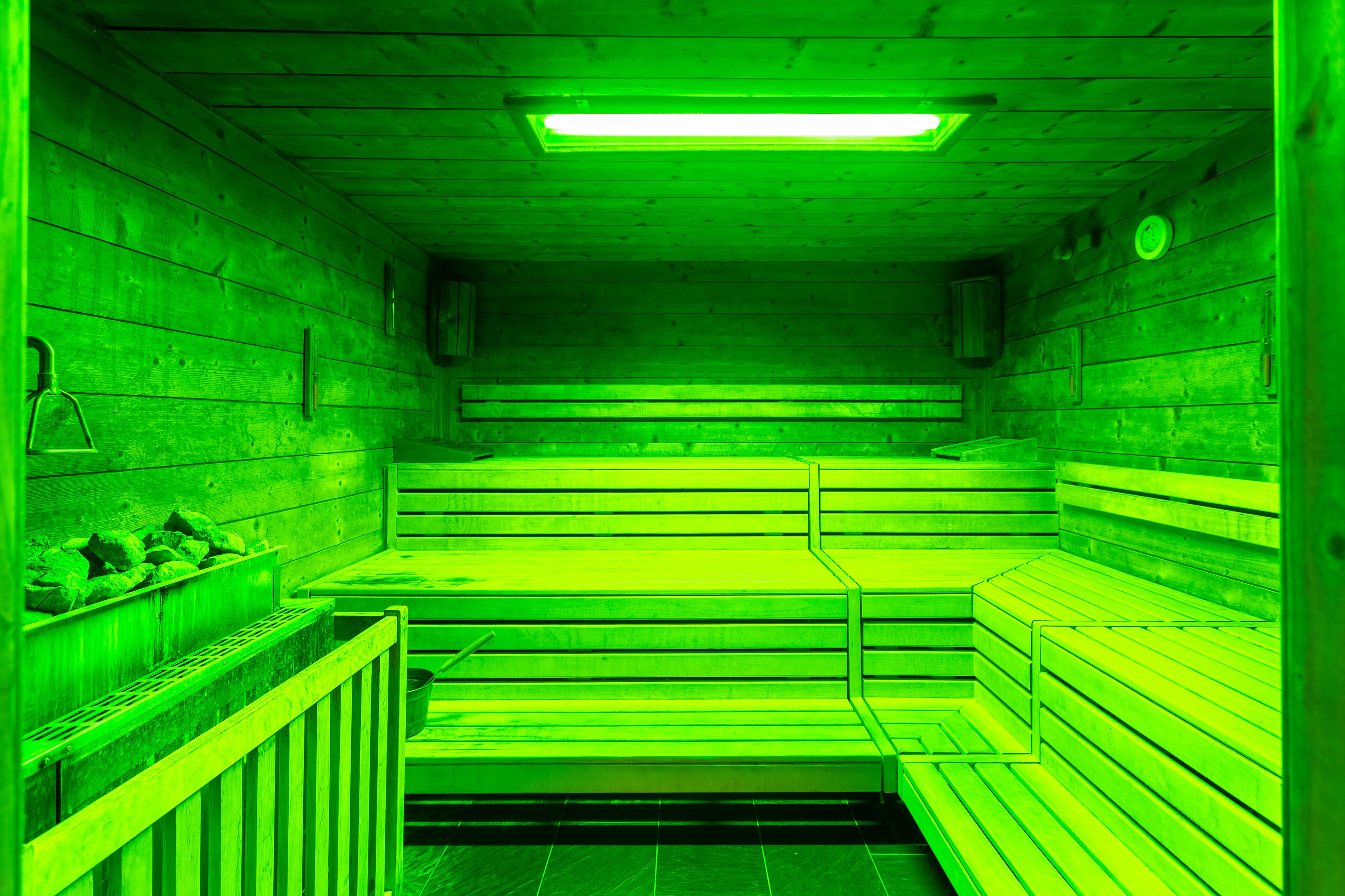 Una sauna con bancos de madera y un banco a la izquierda.