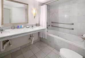 Un bagno con lavandino, specchio, doccia e water.