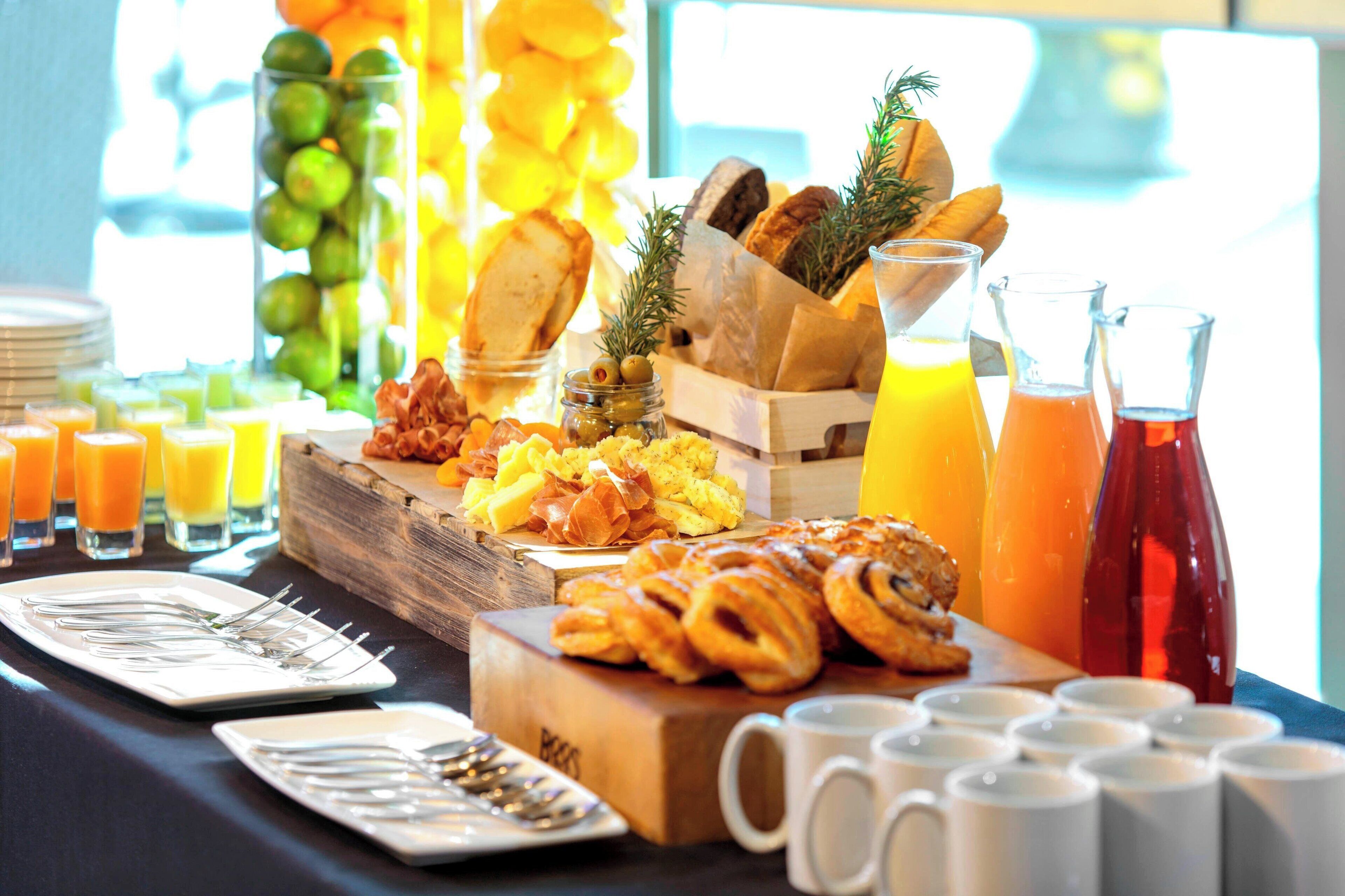 A breakfast buffet with various food items, including pastries, fruits, and beverages.