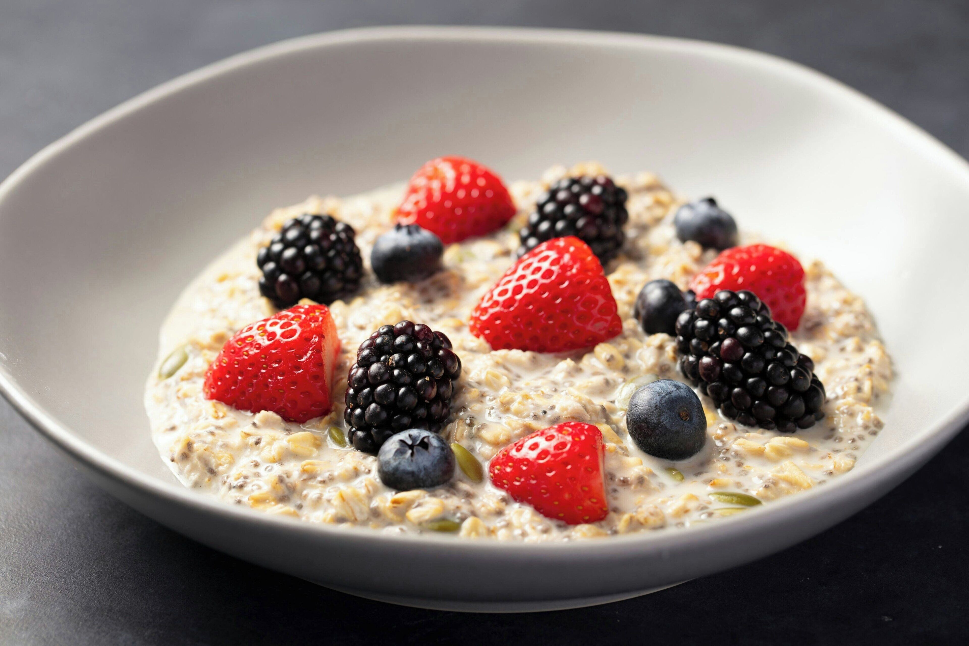 Eine Schüssel Haferflocken mit Erdbeeren, Brombeeren und Blaubeeren.