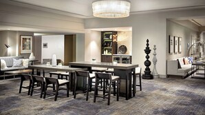 A modern hotel lobby with a central dining area, sofas, and a chandelier. - Renaissance Los Angeles Airport Hotel (Los Angeles)
