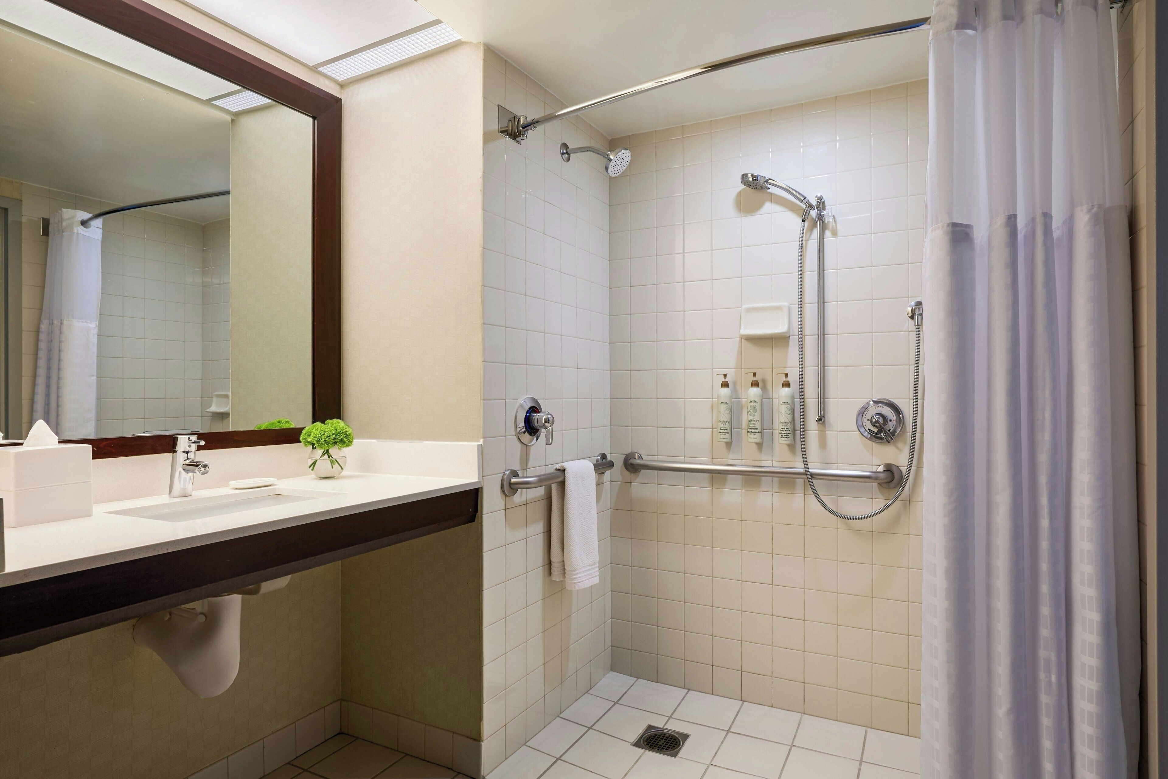 Une salle de bain moderne équipée d’une douche, d’un lavabo, d’un miroir et de toilettes.