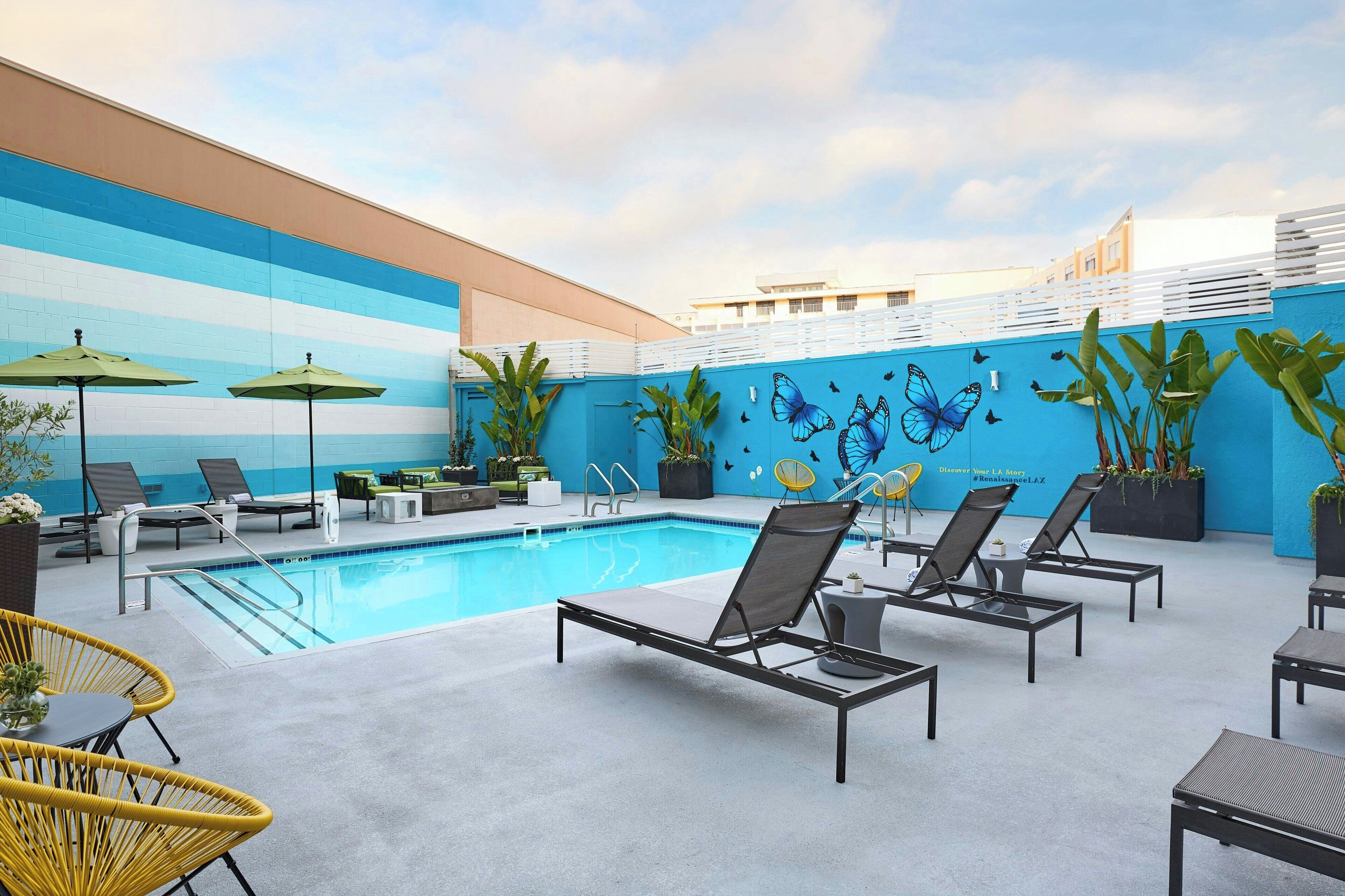 Alberca al aire libre, sombrillas en la alberca y camastros 