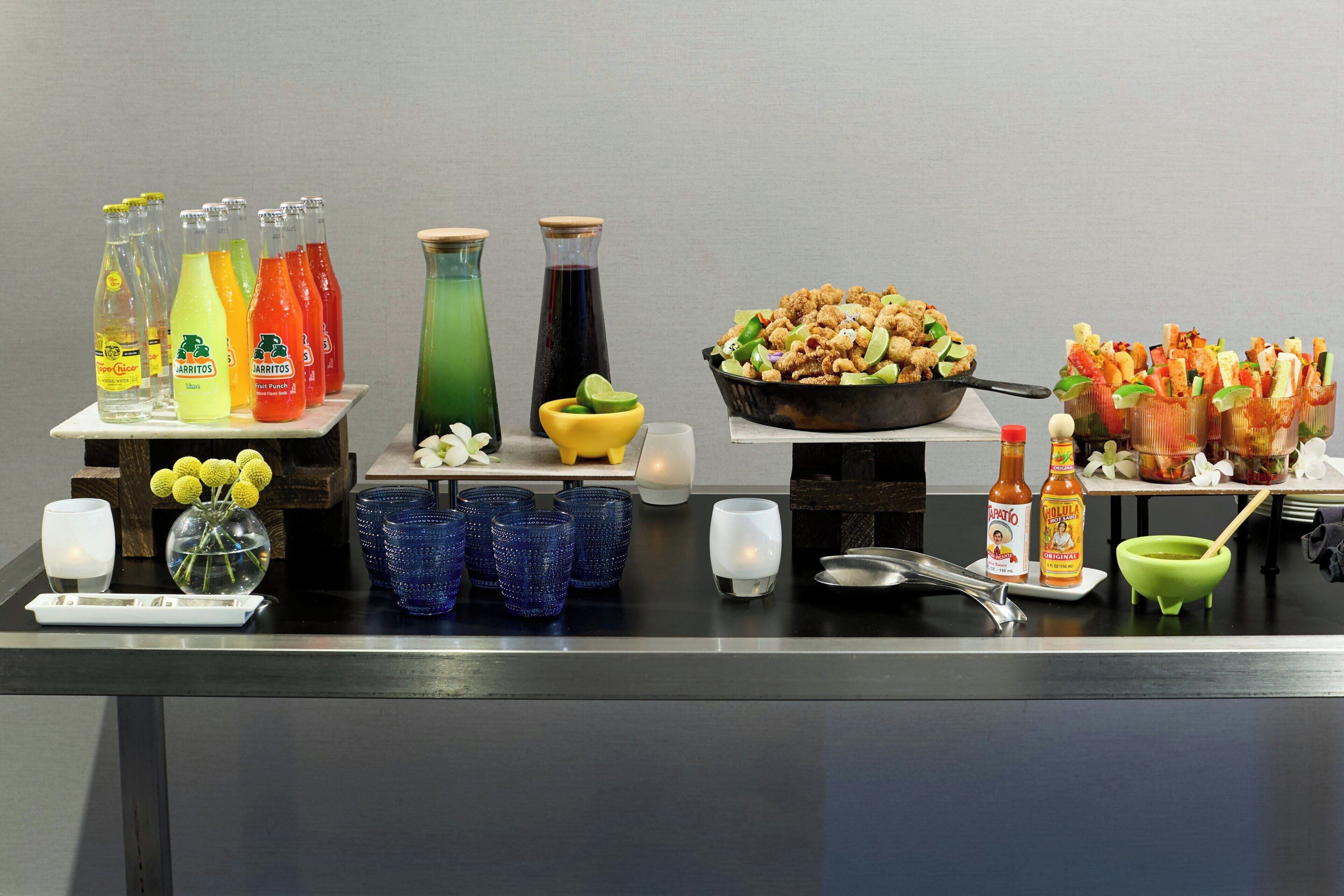 A buffet table with various food items, condiments, and beverages.