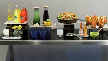 Una mesa de buffet con diversos alimentos, salsas y bebidas.