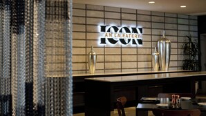 Moderni ravintolan sisustus, jossa on laatoitetulla seinällä suuri kyltti, jossa lukee: ”ICON AN LA EATERY”.