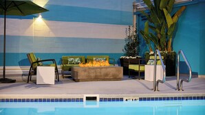 A poolside area with a fire feature, seating, and a potted plant. - Renaissance Los Angeles Airport Hotel (Los Angeles)
