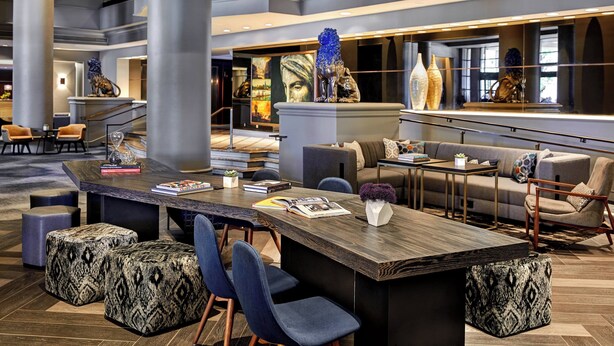 A modern lobby with a central bar area, seating, and a large mural. - Renaissance Los Angeles Airport Hotel (Los Angeles)