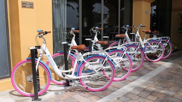 Varias bicicletas estacionadas frente a un edificio con un letrero que indica prohibido fumar.