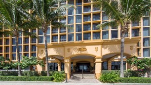 Un hotel de varios pisos con fachada simétrica, que cuenta con balcones y una entrada central.
