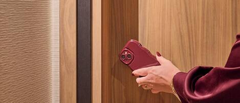 A person unlocking a door with a key and holding a smartphone.
