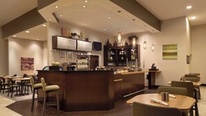 Eine moderne Bar mit Theke, Sitzgelegenheiten und einer Speisekarte.