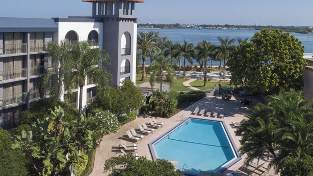 Ein Resort mit Pool, Palmen und Blick auf das Wasser.