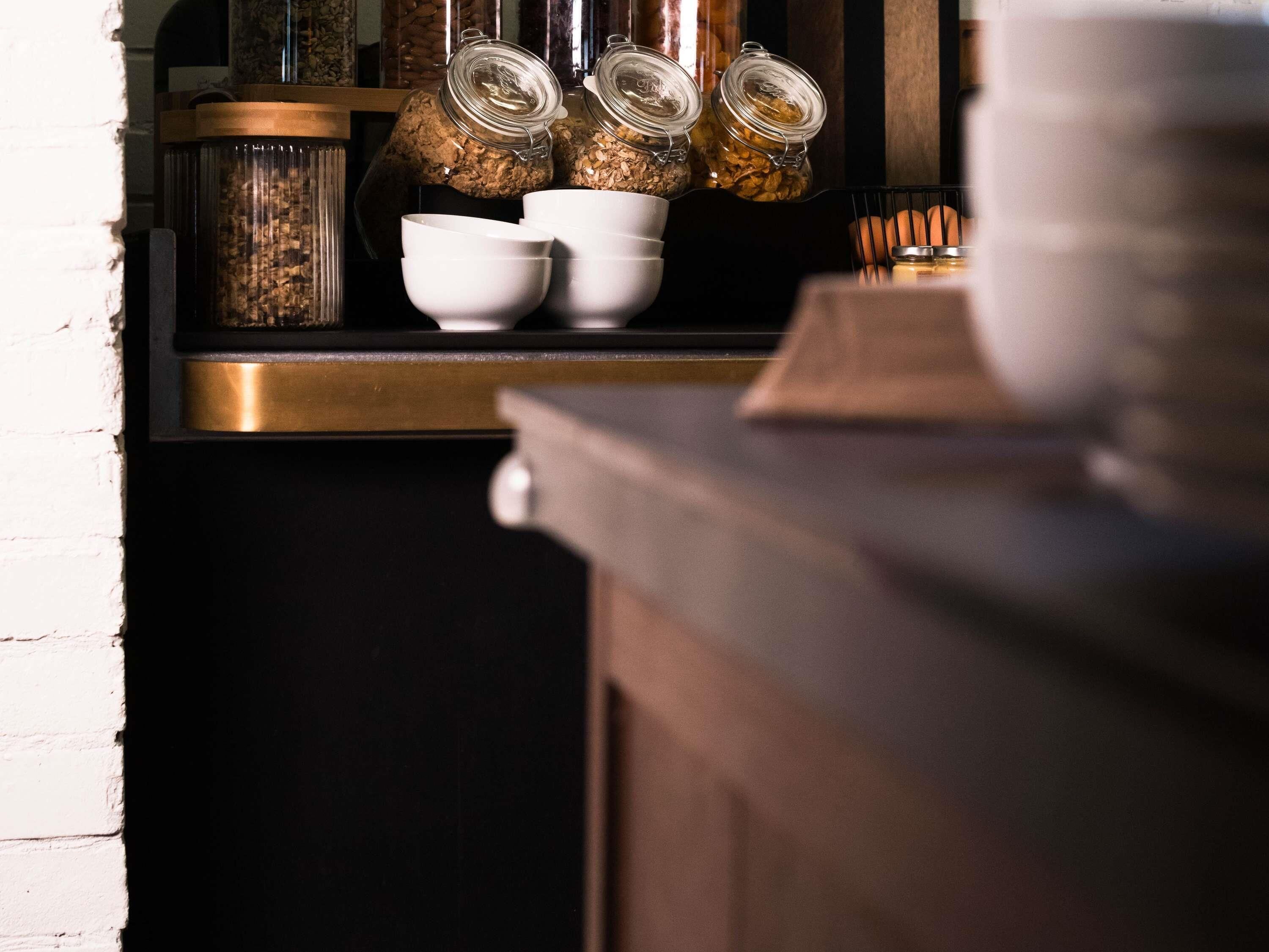 A kitchen counter with jars of grains, a coffee maker, and a toaster.