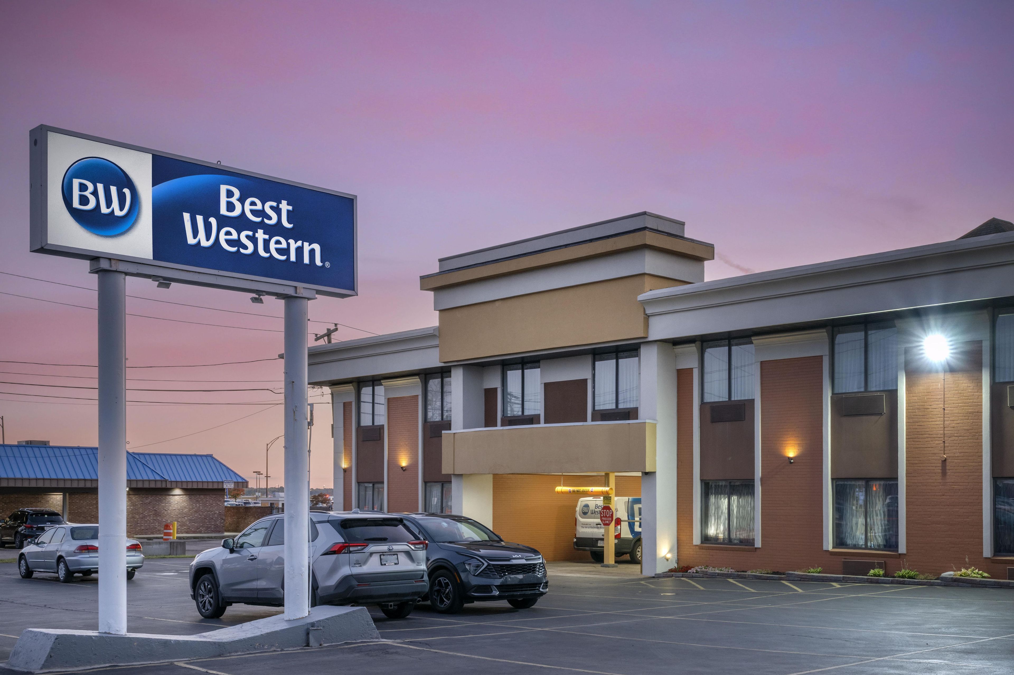 Modernilla julkisivulla varustettu Best Western -hotelli, jossa on useita parkkipaikkoja autoille ja kirkas taivas.