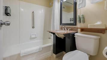 Une salle de bain équipée d’une baignoire, de toilettes, d’un lavabo, d’un miroir et d’un porte-serviettes.