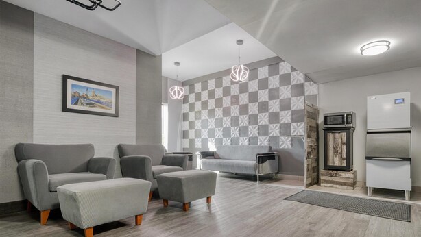 A modern living room with grey sofas, a coffee table, and a patterned wall. - Best Western The Inn At Rochester Airport (Rochester)
