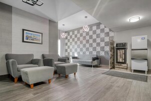 Una sala de estar moderna con sofás grises, una mesa de centro y una pared con diseño.