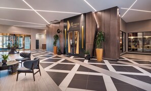 Een moderne zithoek met een geruite vloer, meubels en potplanten.
