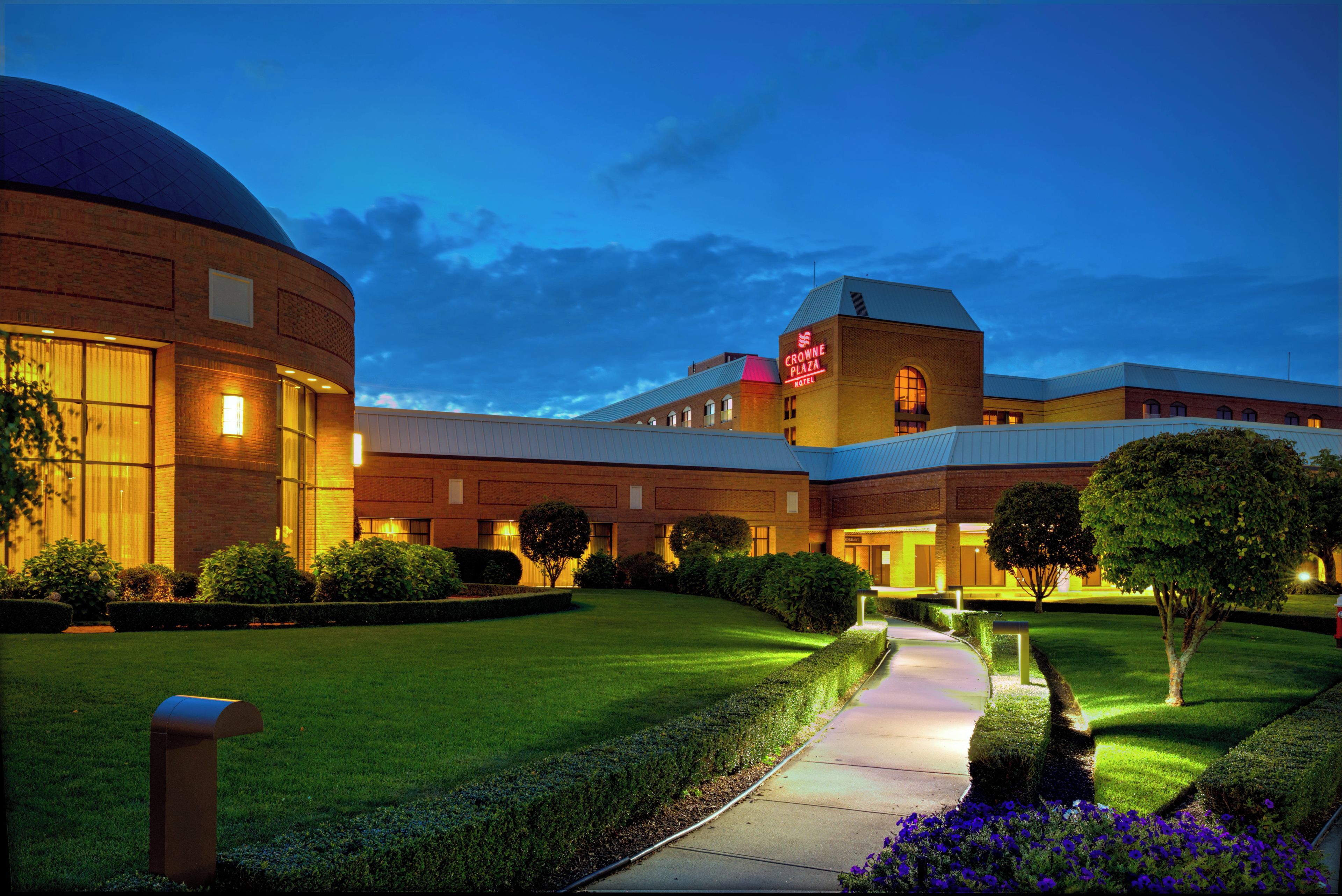 A hotel with a large circular building, a central courtyard, and a well-lit entrance.