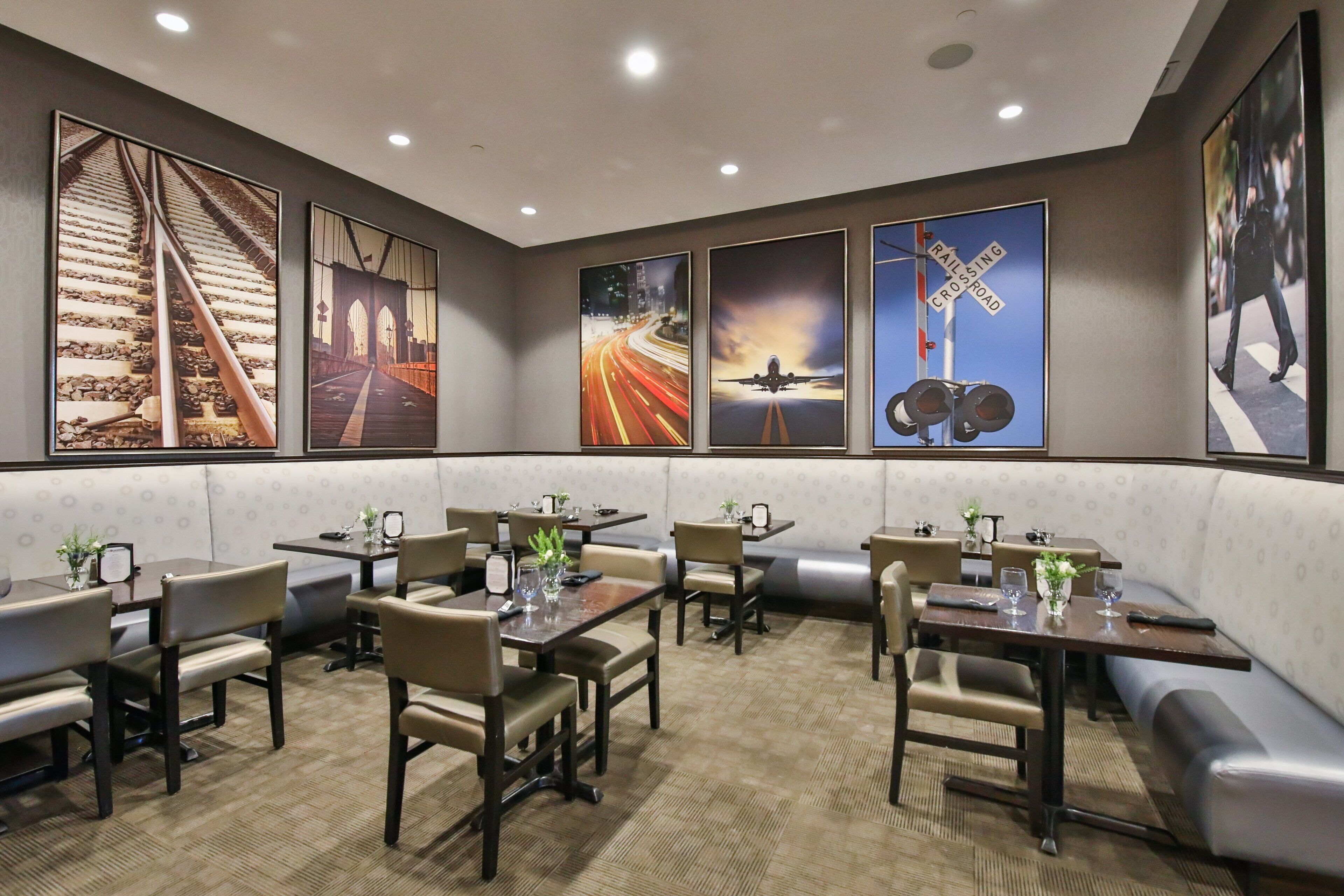 A restaurant with booths and tables, featuring artwork on the walls.