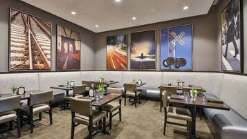 A restaurant with booths and tables, featuring artwork on the walls.