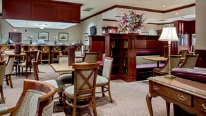 Une bibliothèque dotée de meubles en bois, d’étagères et d’un arrangement floral central.