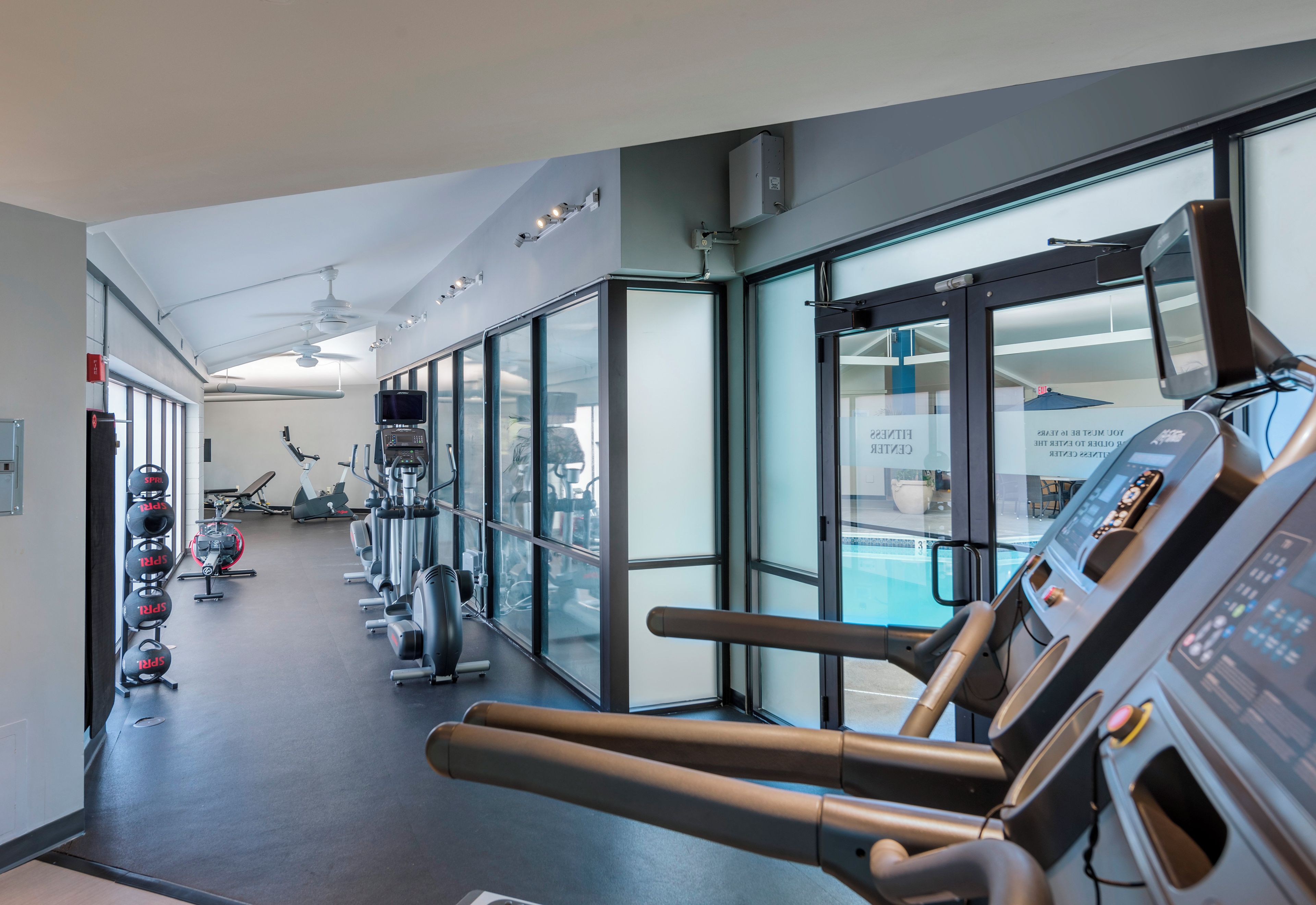 A gym with treadmills, exercise bikes, and weight machines.
