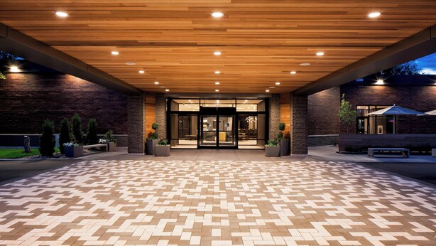 A hotel entrance with a patterned tile floor, wooden ceiling, and brick walls. - Delta Hotels by Marriott Minneapolis Northeast (Minneapolis)