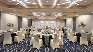 A banquet hall with round tables, white chairs, and a blue carpet. - Delta Hotels by Marriott Minneapolis Northeast (Minneapolis)