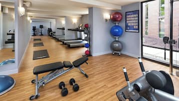 A gym with treadmills, exercise balls, and dumbbells.