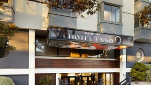 Una entrada de hotel moderna con un letrero que dice "KIMPTON HOTEL ENSO".