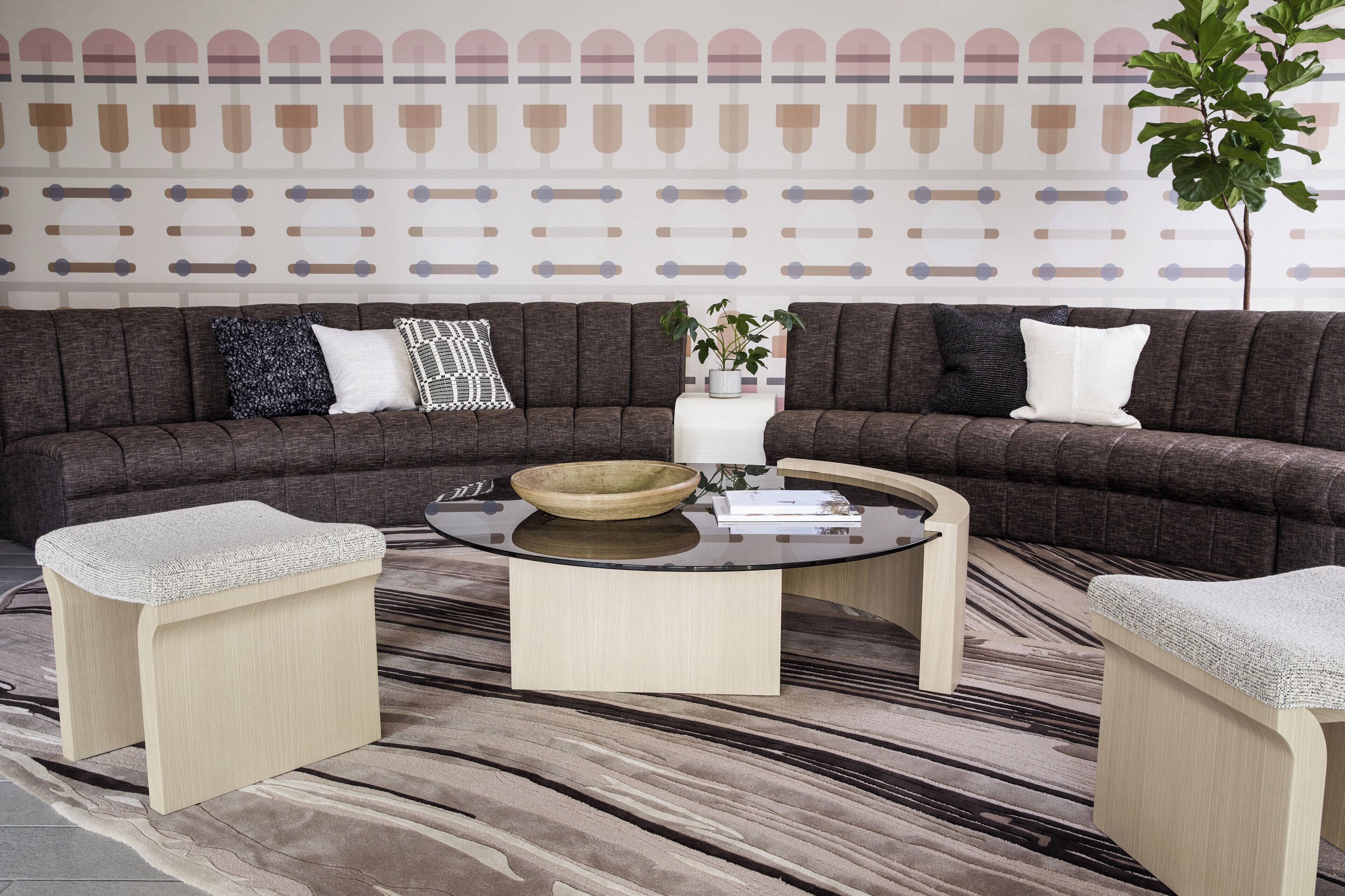 A modern living room with a sectional sofa, two side tables, a coffee table, and a decorative wall.
