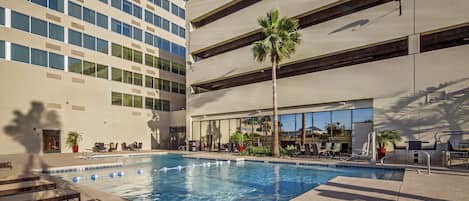 Una piscina al aire libre, sillones reclinables de piscina