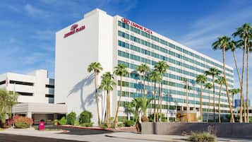 Experience the sleek, modern design of Crowne Plaza, surrounded by lush palm trees in an urban setting.