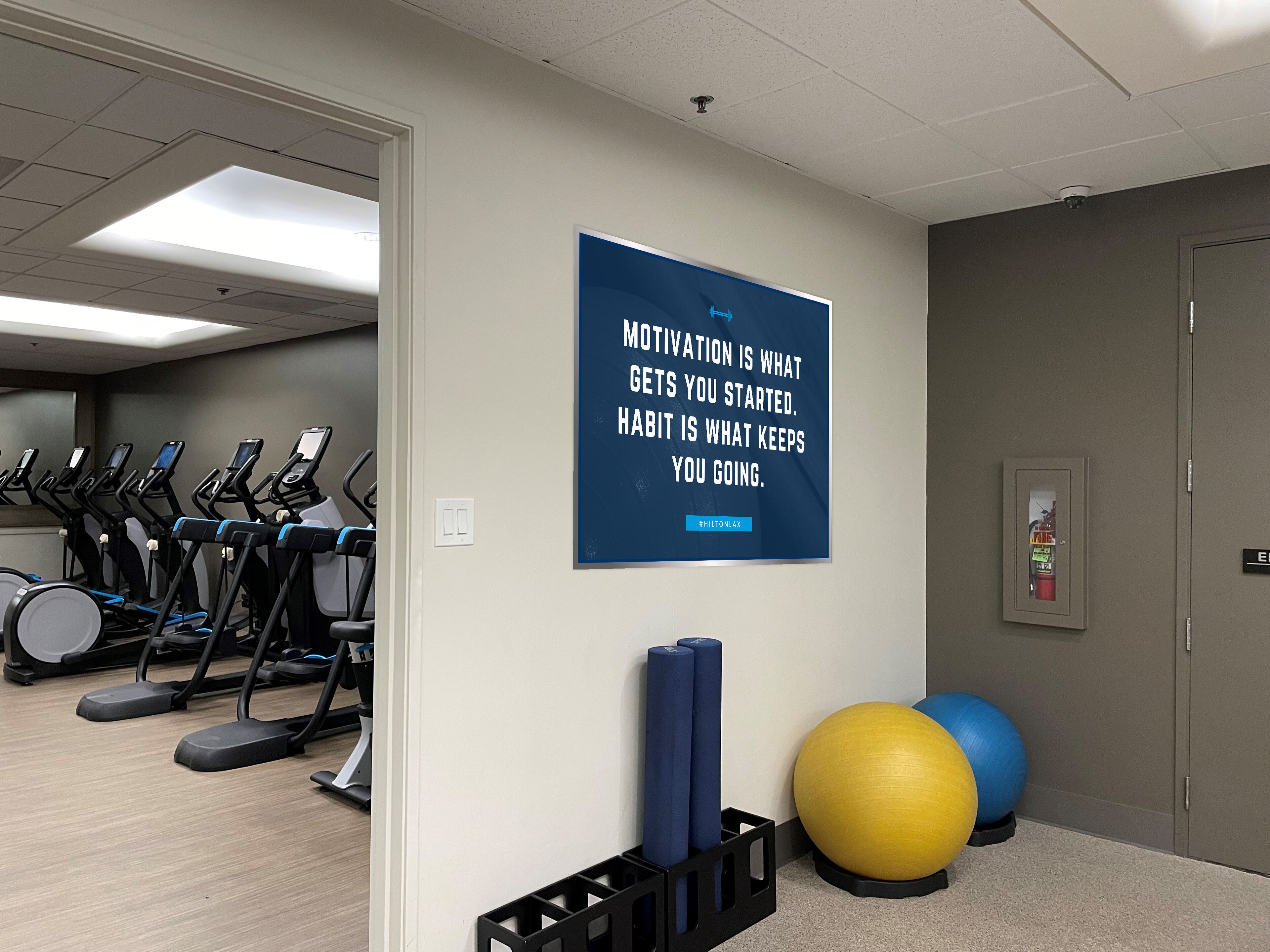 Une salle de sport équipée de tapis de course, de tapis de yoga et de ballons d’exercice.