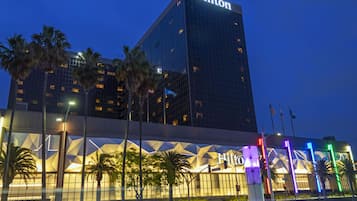 A modern hotel building with a prominent Hilton sign at the top.