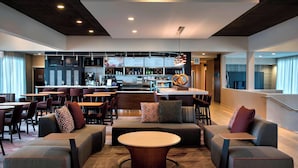 A modern hotel lobby with seating areas, a bar, and a staircase. - Courtyard by Marriott Poughkeepsie (Poughkeepsie)