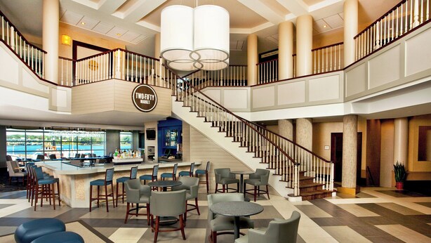 A spacious lobby with a bar area, seating, and a staircase connecting multiple floors. - Sheraton Portsmouth Harborside Hotel (Portsmouth)