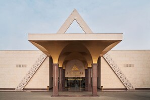 A modern building with a prominent triangular entrance and a sign reading "PYRAMIDS".