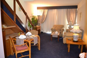 Deluxe Suite | Living room | 32-inch LCD TV with satellite channels, TV