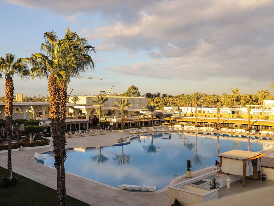 Una piscina al aire libre, camas de piscina con cargo, sombrillas