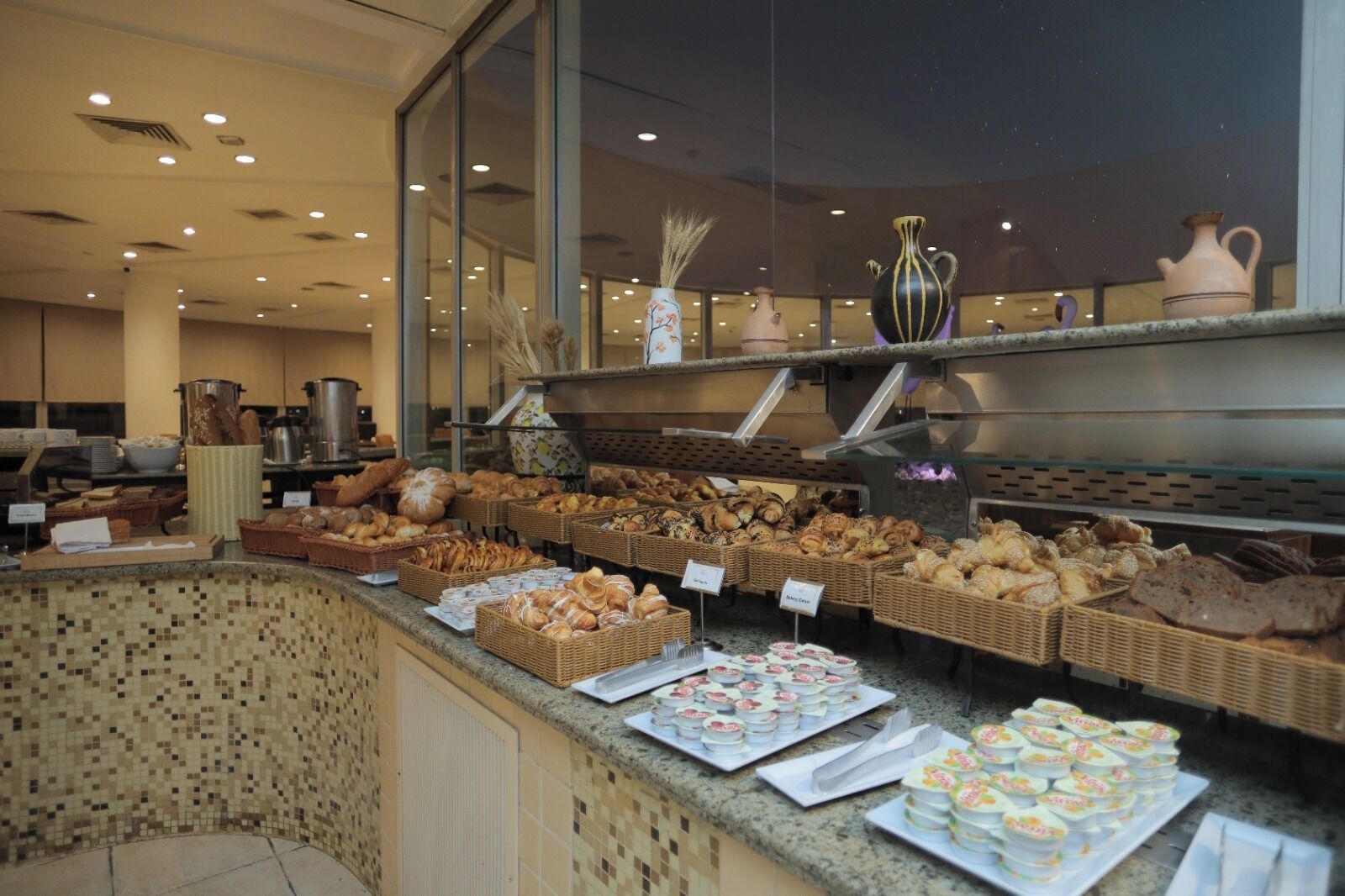 Mostrador de una panadería con diversos productos horneados y pasteles exhibidos en cestas y bandejas.