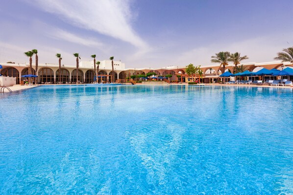 Una piscina al aire libre, cabañas de piscina (de pago), sombrillas