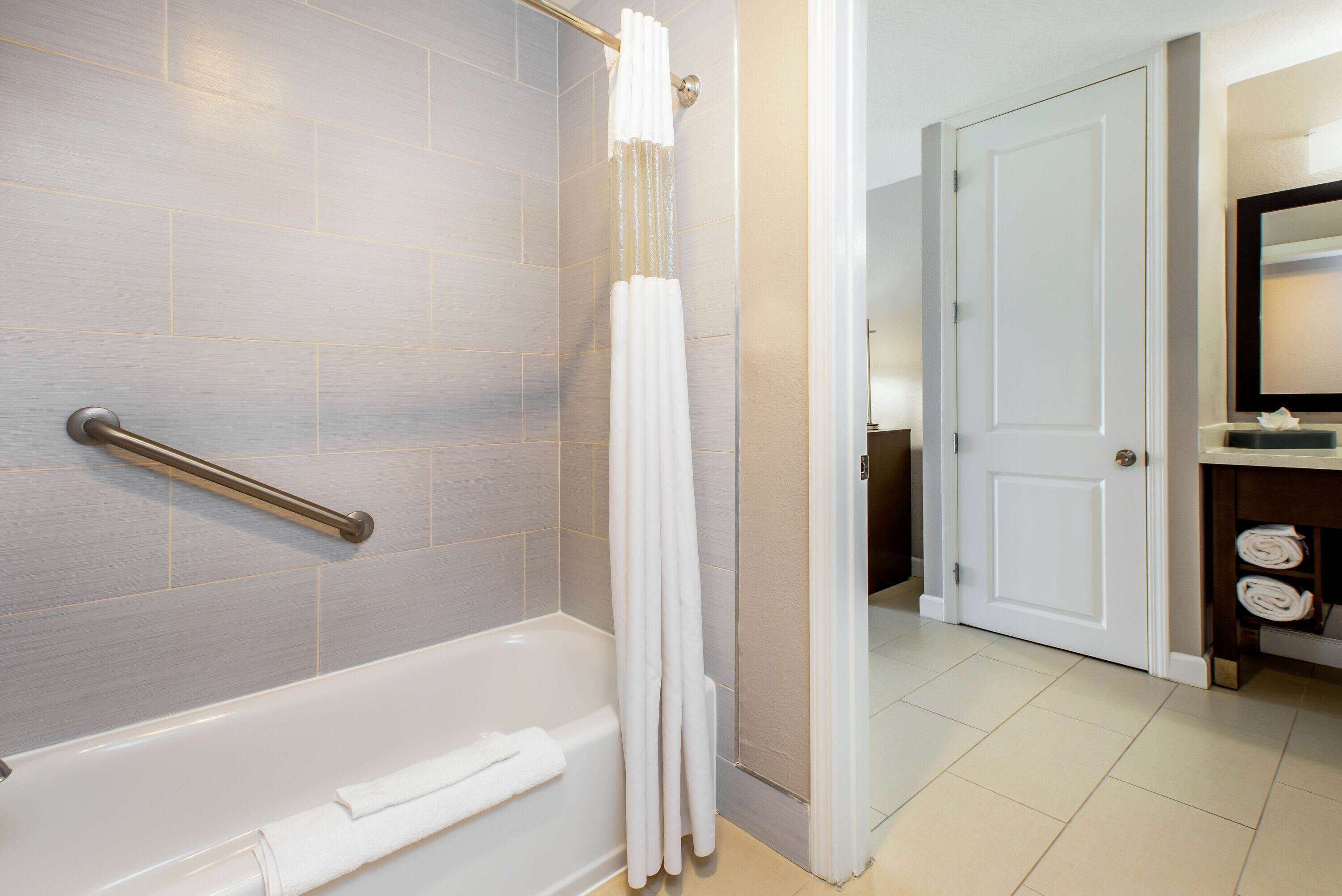 Une salle de bain avec une baignoire, un rideau de douche et un porte-serviettes.